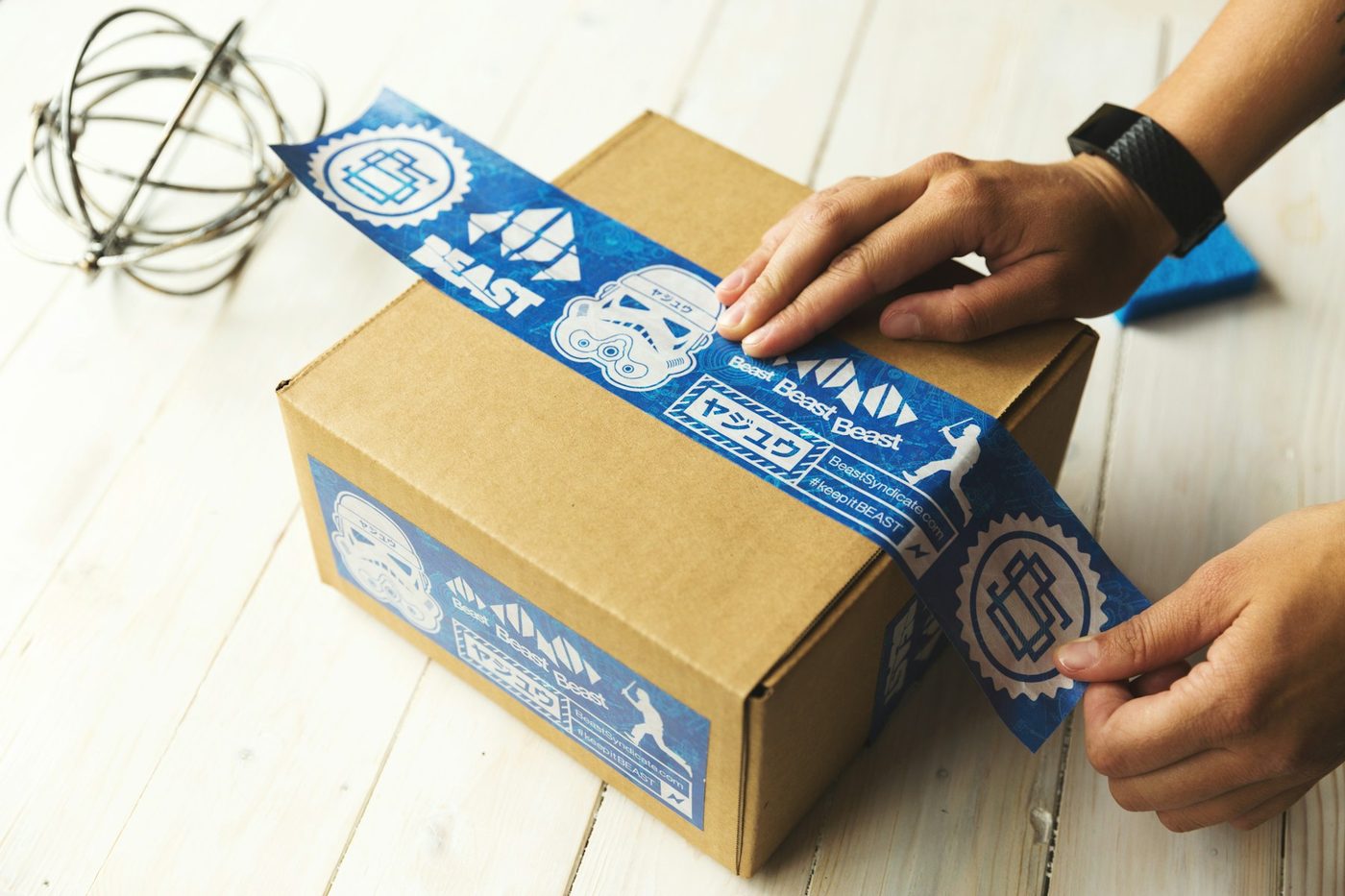 Mains apposant une étiquette sur un colis en carton